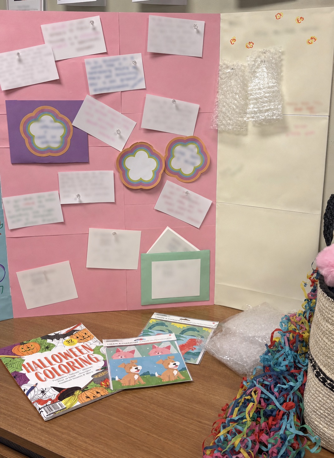 Colorful activity display with an affirmation board, bubble wrap, coloring pages, and craft materials