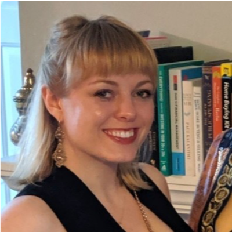 Portrait of Rose Hayes smiling in front of a bookshelf